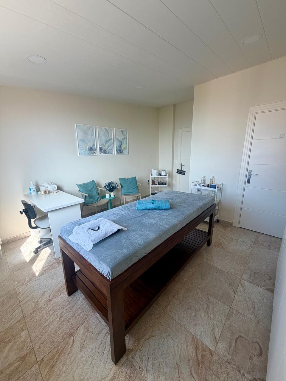 Treatment room with massage table and workstation