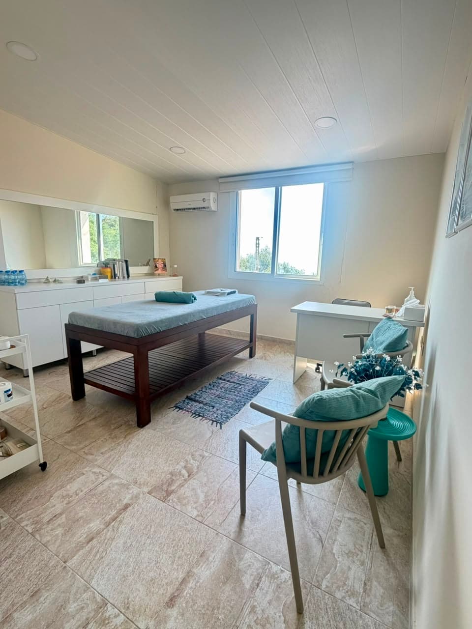 Treatment room with massage table and seating area